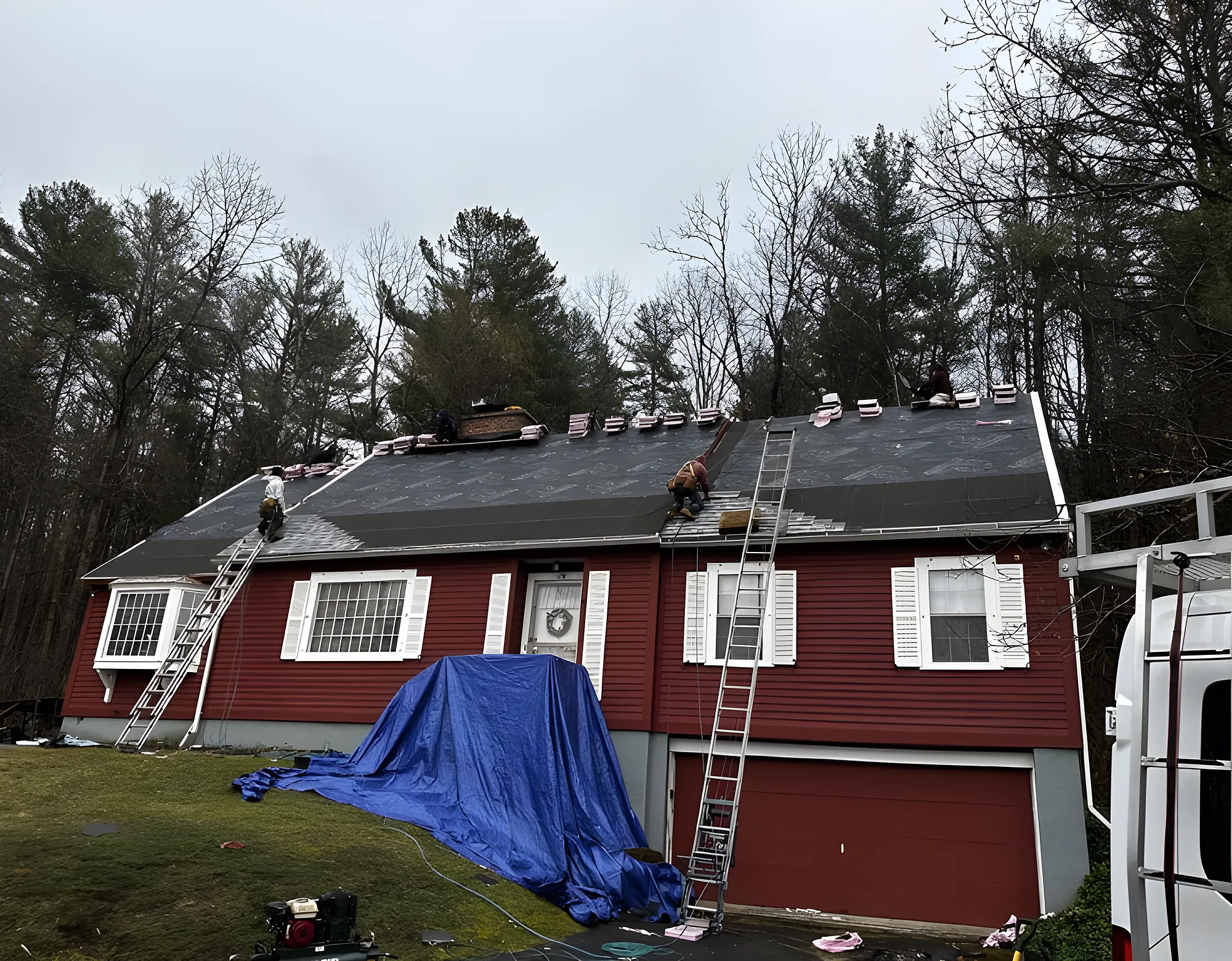 Crew re-roofing a red two-story home
